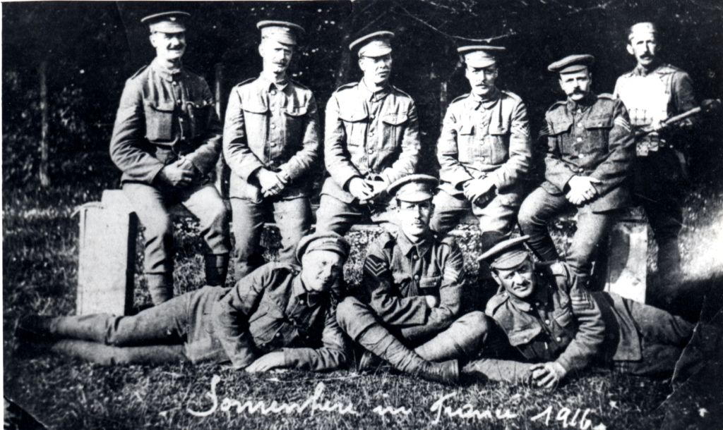 Joseph Arnold Sadler sitting cross legged with a group of soldiers