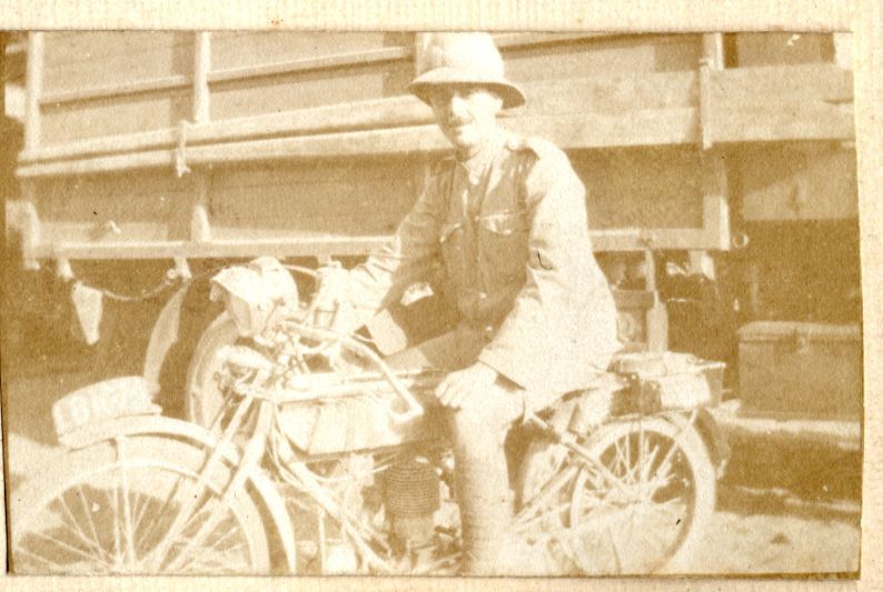 sepia photograph of alfred on a motorbike, he is wearing his army uniform