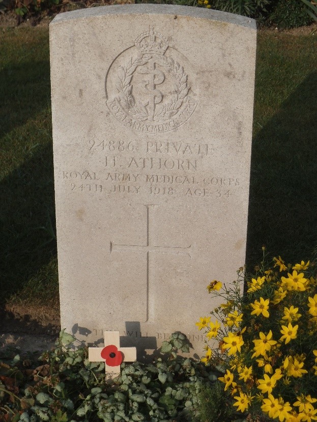 Close up of his gravestone. The details of his service number, name, regimental badge are inscribed as is a cross and the words Thy will be done