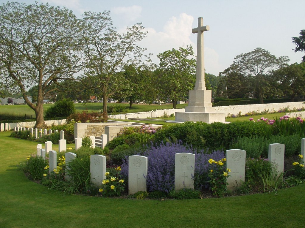 Longuenesse (St Omer) Souvenir Cemetery with gravestones surrounding the Cross of Sacrifice
