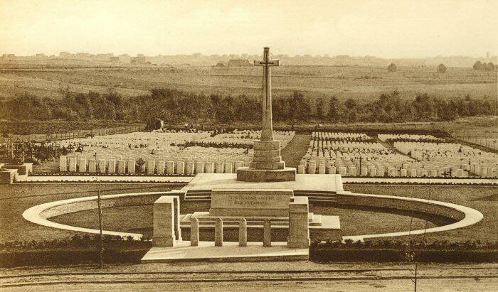 Sepia photograph of Hooge Crater Cemetery with the Cross of Sacrifice and rows of graves behind