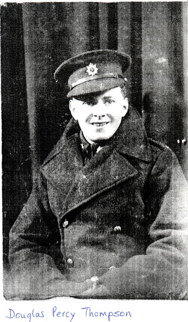 black and white photograph of douglas wearing an army great coat and an army cap