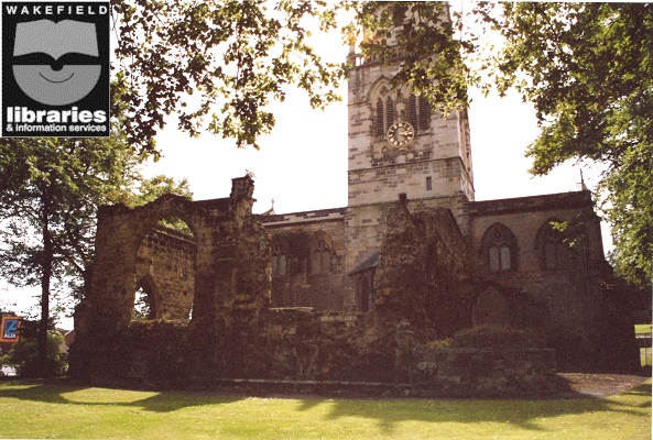 A colour photograph of the exterior of All Saints Church, Pontefract. The sign for Aldi supermarket is just visible. Internal Ref: PO
