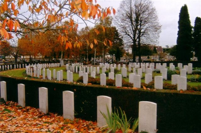 Photo of St Sever Cemetery. Rows of white headstones with fallen orange leaves in the foreground.
