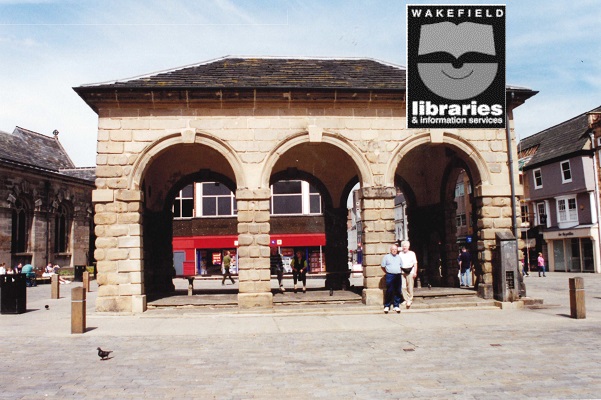 A colour photograph of the Buttercross, Pontefract. Mr R Gosney, local historian, is in front of it with his wife. Internal Ref: PO
