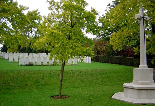 Villers-Pol Communal Cemetery with the Cross of Sacrifice in the foreground and rows of graves behind