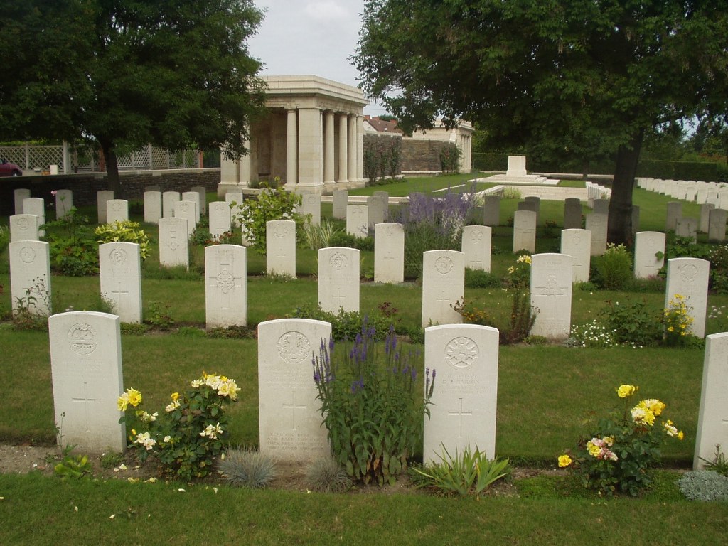 Vermelles British Cemetery with rows of gravestones and flowers in between the gravestones
