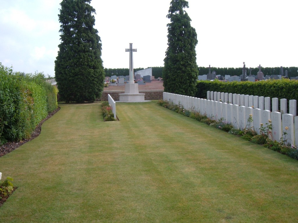 Neuvilly Communal Cemetery Extension with rows of gravestones surrounded by a hedge