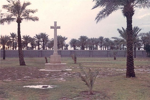Amara War Cemetery with a stone cross surrounded with palm trees