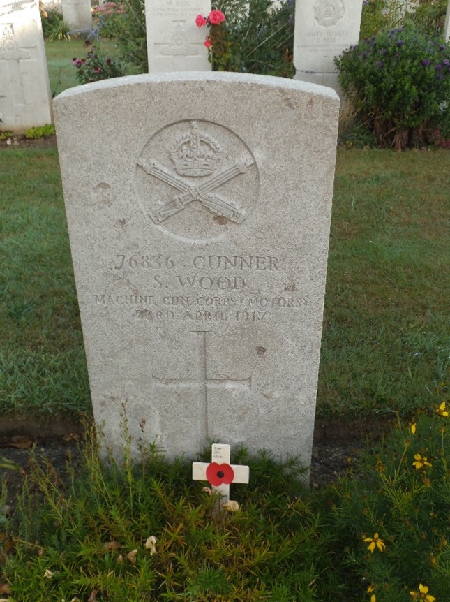 sam wood's white gravestone giving his details and his regimental badge is also inscribed as well as a cross beneath