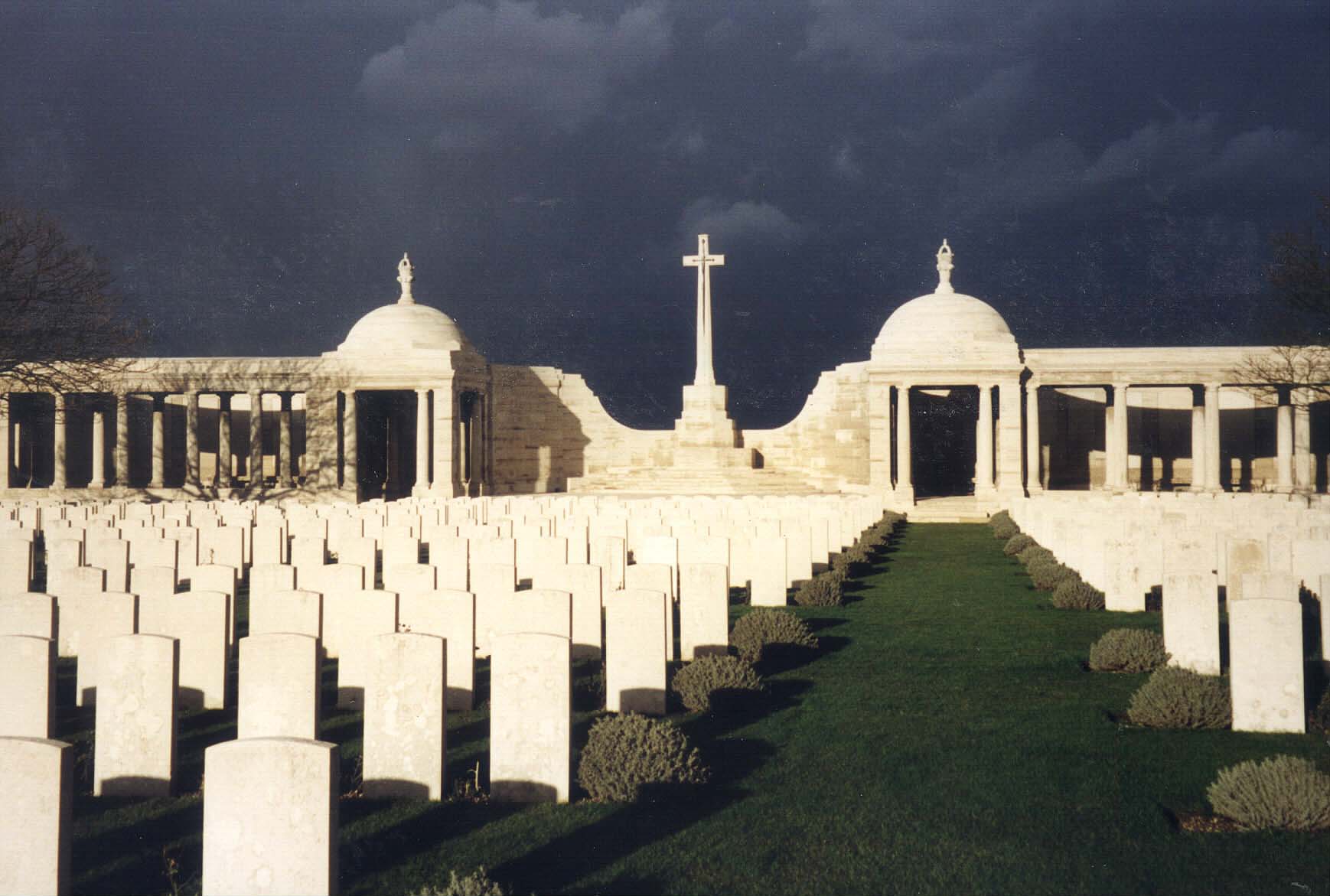 The Loos Memorial in the background with rows of gravestones in front
