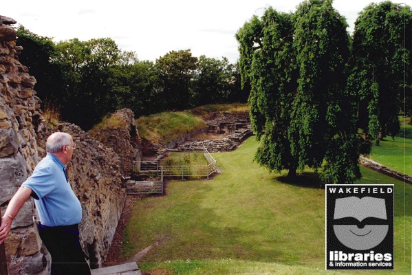 A colour photograph of Pontefract Castle, taken from the steps of the keep. Local historian Mr R Gosney can be seen on the left. Internal Ref: PO
